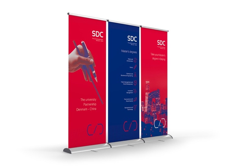 SDC's visuelle identitet bruges på roll-ups. Den klare og letgenkendelige identitet gør det let at afkode, at SDC er afsenderen. 