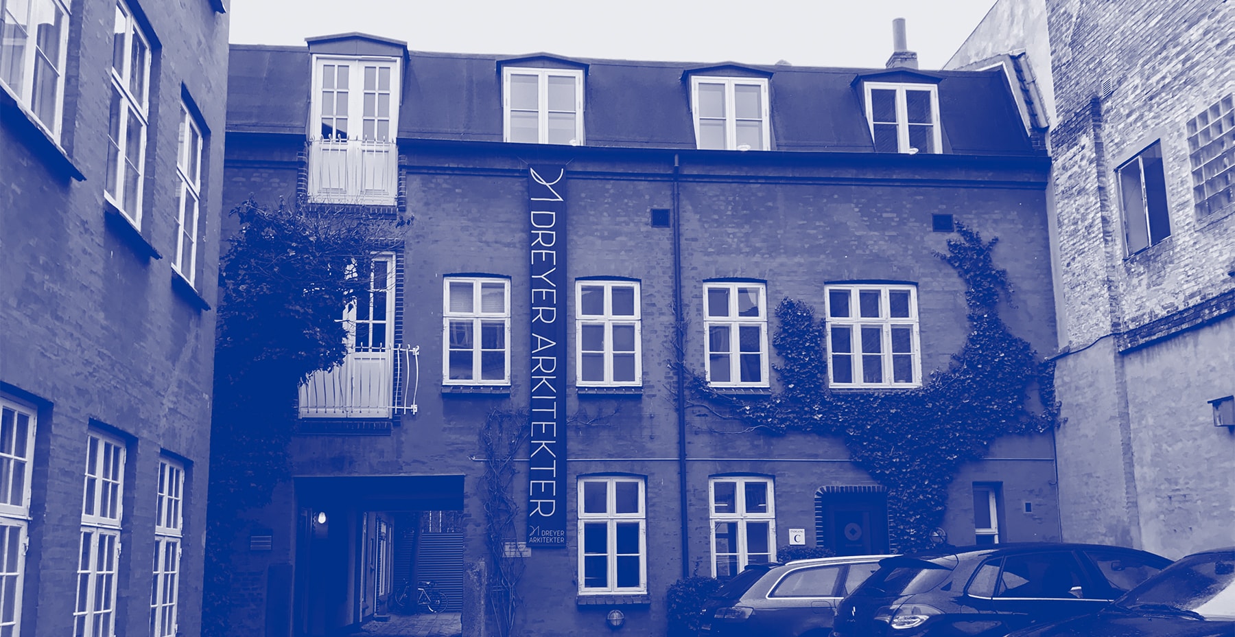 Billede af facaden hos Aarhusianske Dreyer Arkitekter, der er blevet tilført blåt farvefilter, som matcher den visuelle identitet. 