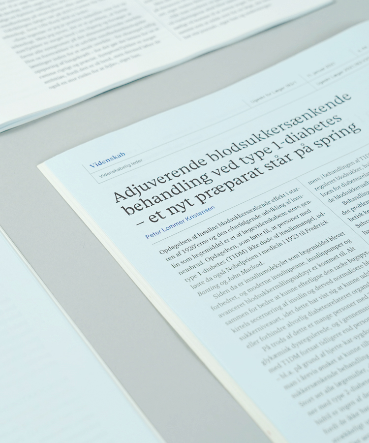 Redesign af lægeforeningens ugeskrift er placeret side om side på et bord, og øverste højre hjørne ses her med overskrift og tekst.